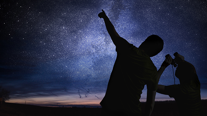 space science image depicting sillouette of person pointing at night sky