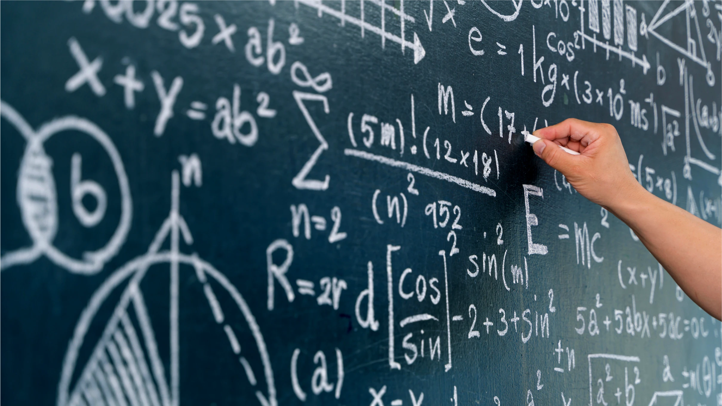 hand writes on chalkboard covered with equations